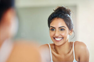 Cropped of an attractive young woman looking at her face in the bathroom mirror