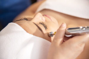 woman getting lifting anti-aging, face massage and skincare by electroporation facial therapy aesthetic cosmetology