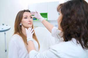 Patient sitting in a chair on examination by a dermatologist