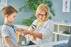 Pediatric Dermatologist examining little kids in clinic