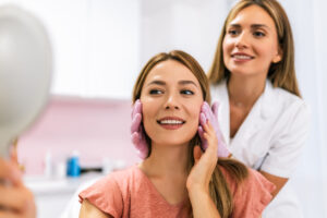 A dermatologist examines the patient before the aesthetic procedures.